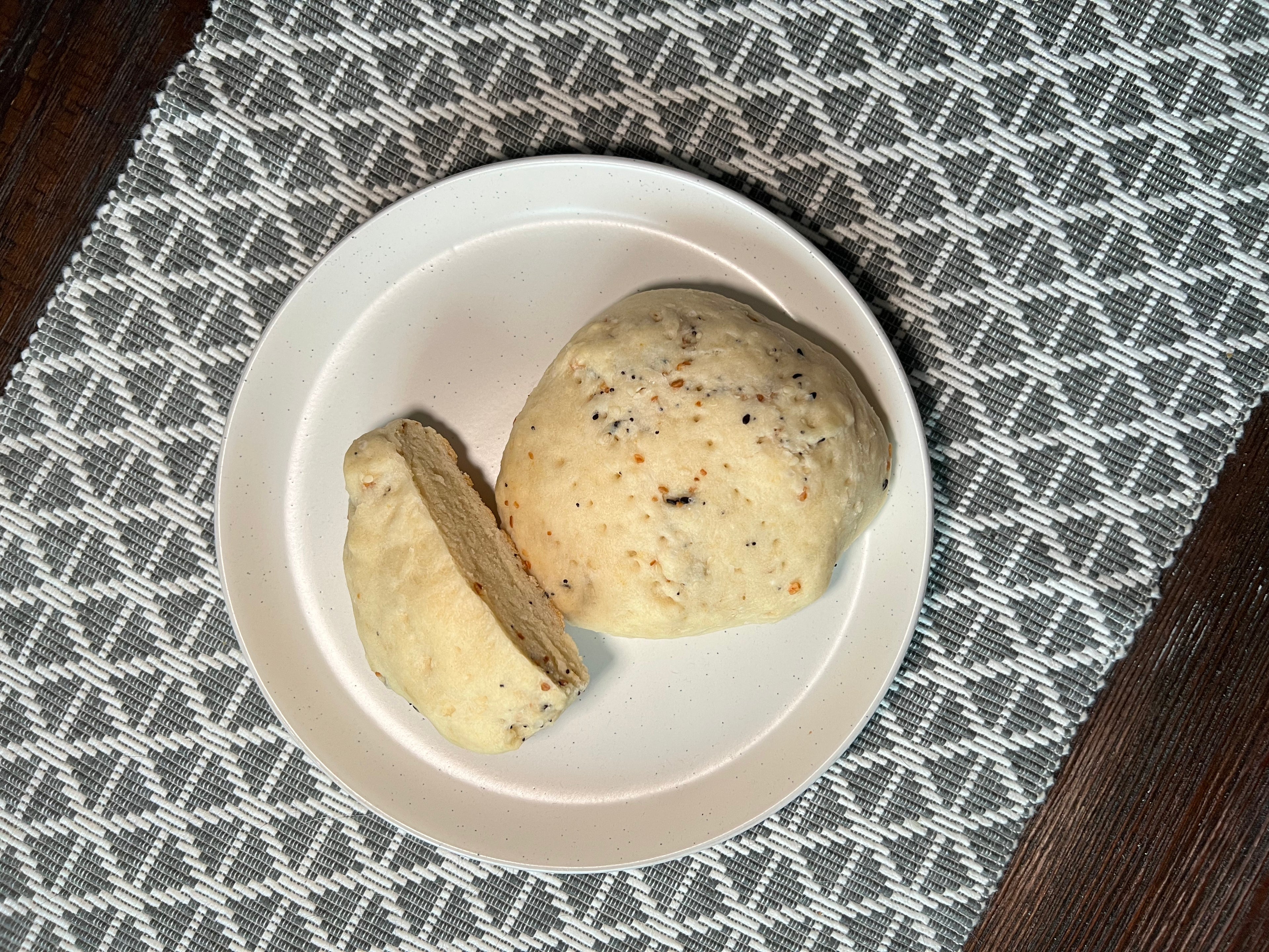 Everything bagel flavoured bannock, one sliced in half, on a plate. 